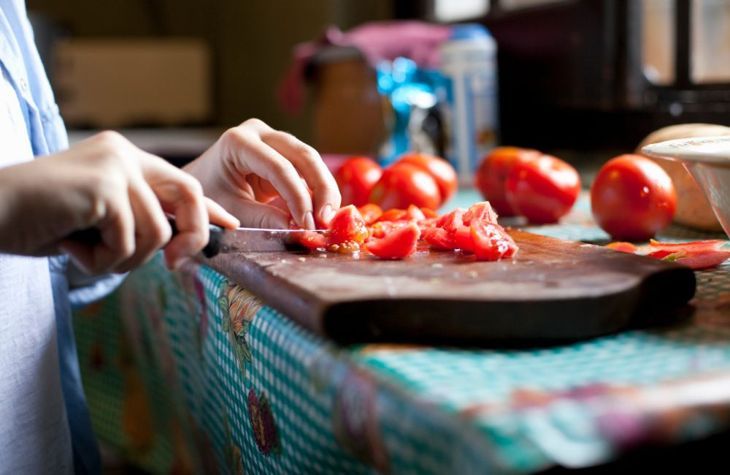 würfeln und Tomaten zum Chili geben
