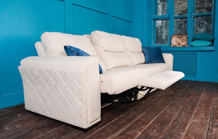 weiße Couch mit Liege in einem hellblauen Raum