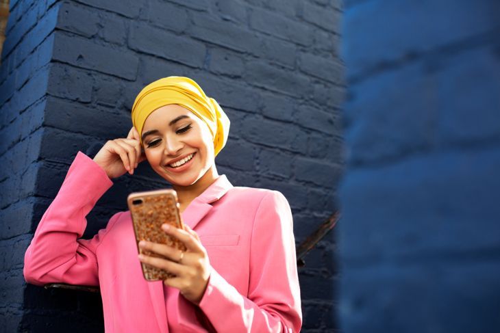 Junge muslimische Frau mit Telefon