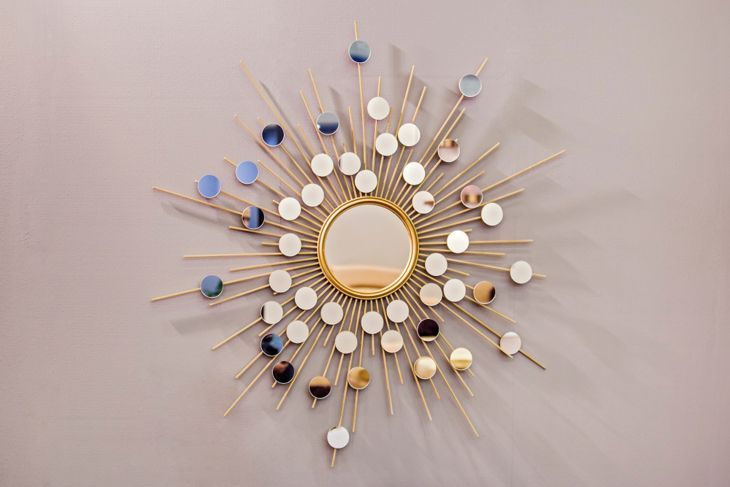 Dekorativer runder Wandspiegel in Form der Sonne, ein goldener Kupferspiegel, moderne Form im skandinavischen Stil.