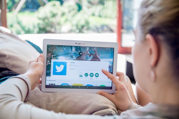 Frau installiert Twitter-Anwendung auf Lenovo-Tablet.