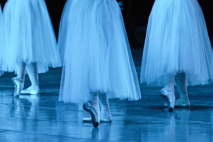 Gruppe von Ballerinas im weißen Chopin-Tutu synchronisiert tanzend auf der Bühne.