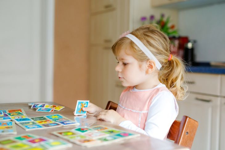 kleines Mädchen, das ein Speicherkartenspiel spielt