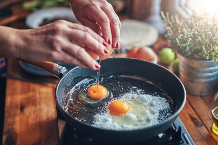 Braten von Ei in einer Kochpfanne in der Privatküche