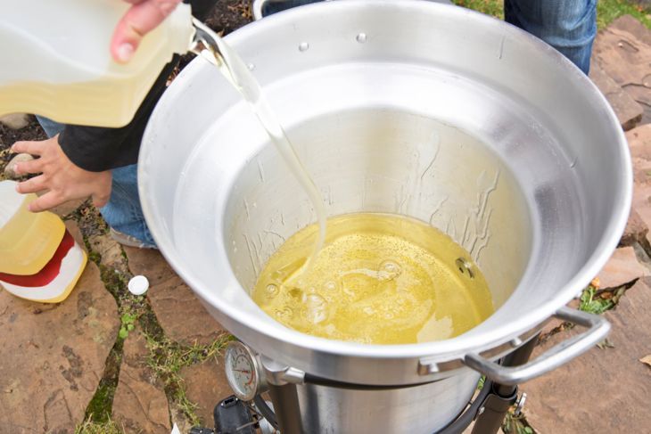 Gießen Sie Öl in eine Outdoor-Fritteuse, um Thanksgiving-Truthahn zu braten