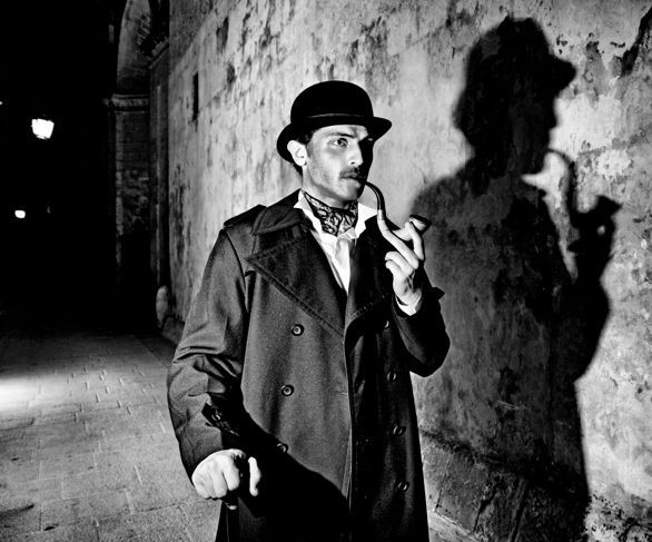 Schwarz-Weiß-Bild eines Detektivs, der seine Pfeife raucht