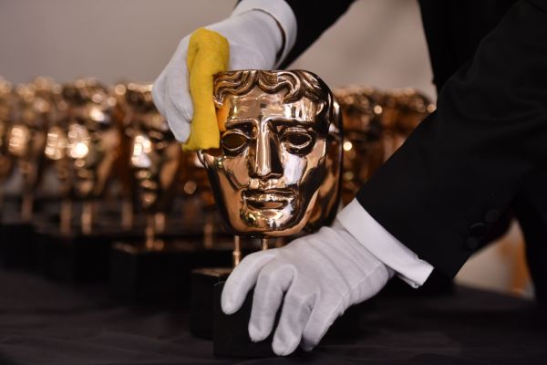 Ein Mitarbeiter poliert die Masken der BAFTA-Preisträger vor der Preisverleihung